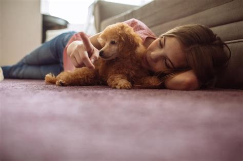 Foto de um adolescente deitado no chão um cachorrinho Foto Premium