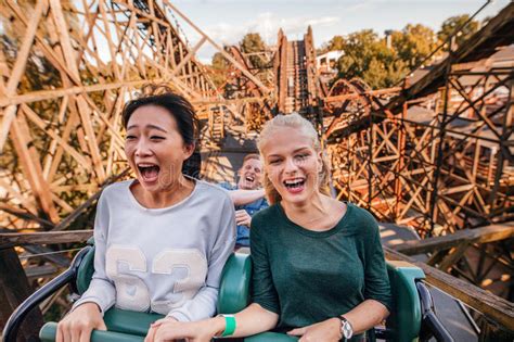 Young Friends Riding Roller Coaster Ride Stock Image