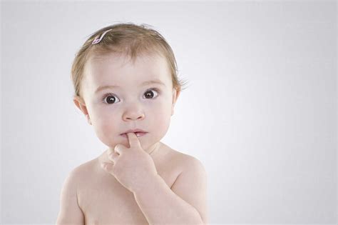 Baby With Finger In Mouth Stock Photo