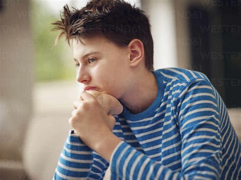 Thoughtful Boy Day Dreaming At Home Stock Photo