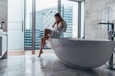 Premium Photo Slim Woman Wearing Bathrobe Sitting On Edge Of Bathtub