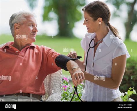 Nurse Checking Senior Mans Blood Pressure Stock Photo Alamy