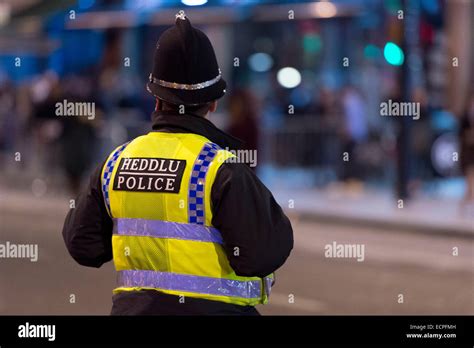 A Police Officer On Patrol At Night In Cardiff City Centre Hundreds Of