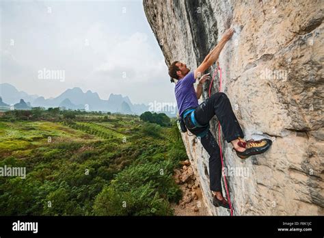 Male Climber Climbing At White Mountain A Limestone Cliff In Yangshuo