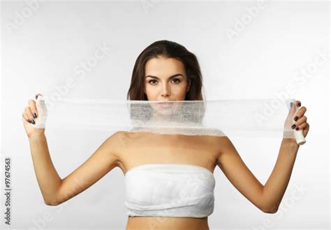 Young Beautiful Woman With A Bandage On Her Chest Holding Gauze Isolated On White Acheter