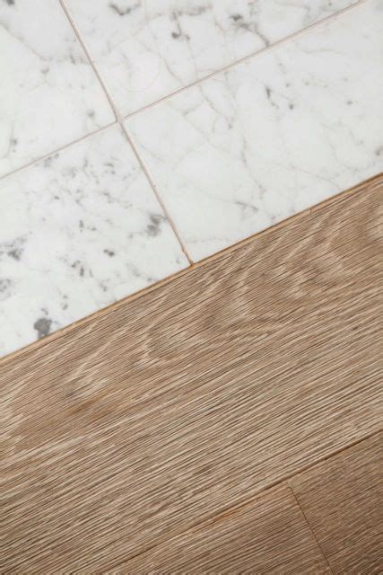 At the floor's edges, place carpet bars to conceal the transition from one surface to the next using a hammer and hacksaw. #Wood to #Marble transition | #white #oak plank border ...