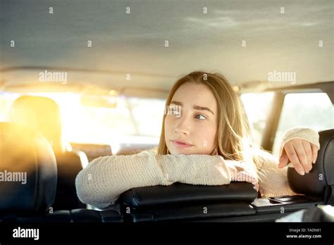 Young Woman Sitting On Back Seat In Car Looking Sideways Stock Photo