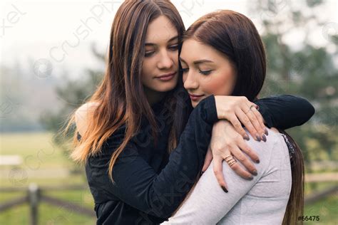 Intense Portrait Of Young Sisters Hugging Outdoors In A Park Stock