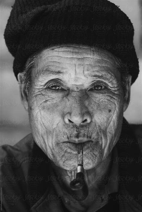 old man smoking pipe by stocksy contributor chalit saphaphak stocksy