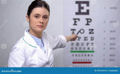 Professional Female Optometrist Showing Letters On Eye Chart Sight
