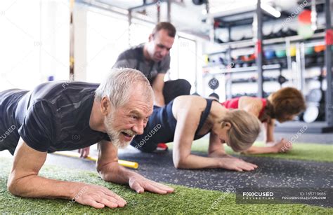 Seniors Exercising With Personal Trainer — Gym Active Stock Photo