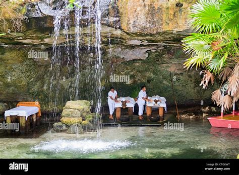 Visitors To Xcaret Enjoy A Massage In A Cave Behind A Waterfall