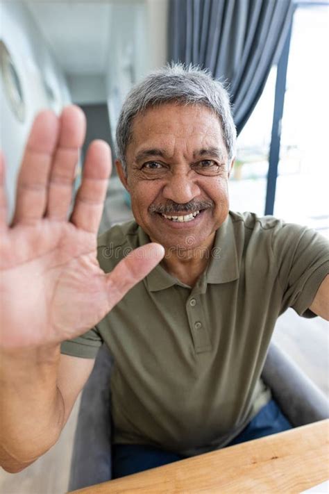 Close Up Portrait Of Cheerful Biracial Senior Man Waving Hand While