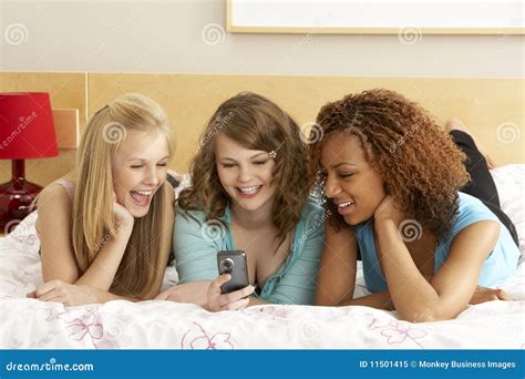 Group Of Three Teenage Girls Using Mobile Phone In Stock Free