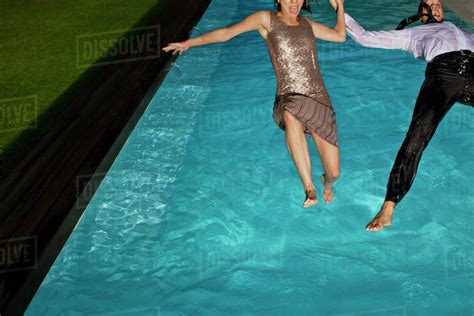 Fully Dressed Couple Jumping Into Swimming Pool Stock Photo Dissolve