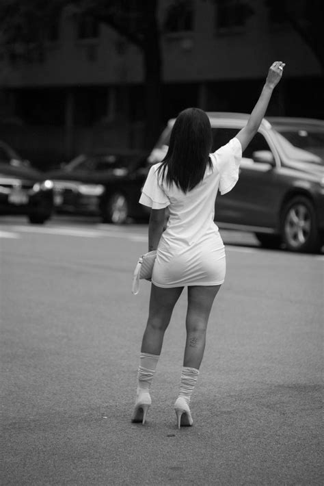 A Woman In Tights Is Standing On The Street With Her Hands Up And Arms Raised