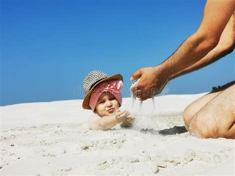 A Small Child Plays In The Sand On The Beach Buried Up To His Head A