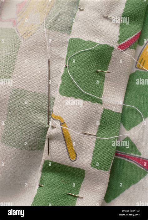 Sewing The Hem Of Green And White Curtains Needle With White Thread