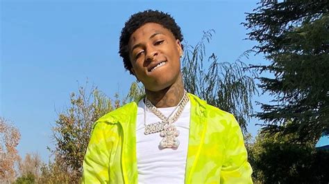 Nba Youngboy Is Wearing White T Shirt And Green Overcoat Standing In