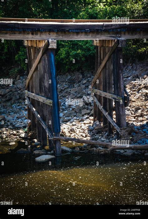 Railroad Track Across A Rickety Wooden Trestle With Stagnant Water
