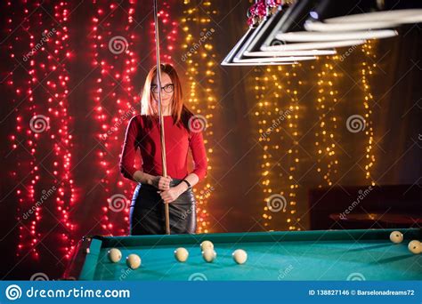 Billiard Club A Woman With In Glasses With Red Hair Standing By The Table Holding A Cue Stock