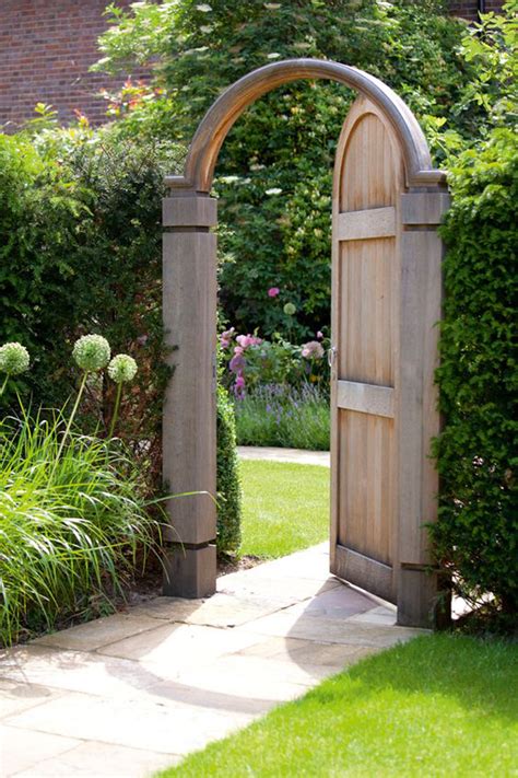 Hollyhocks lean casually against a brick wall. gorgeous-garden-gates-with-modern-design - HomeMydesign