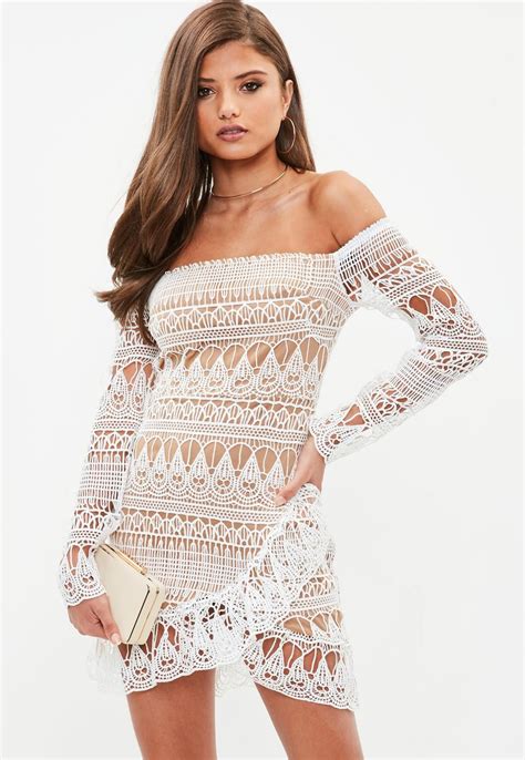 white lace bodycon mini dress with beige under layer long sleeves and bardot elasticated ne