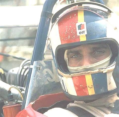 A Man Wearing A Helmet Sitting In A Race Car