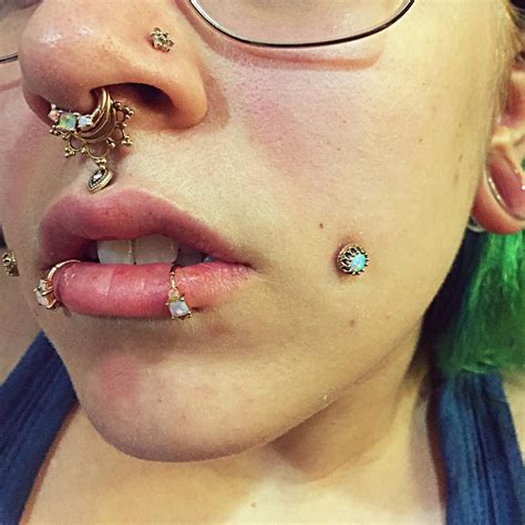 a close up of a person with piercings on her nose and nose ring in front of their face