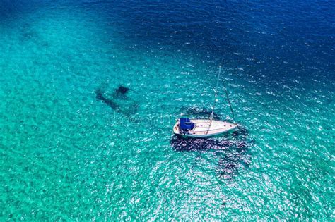 Aerial View Of Anchored Sailing Yacht In Emerald Sea Aerial View Of A