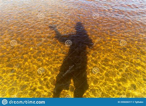 Shadow Of A Man Wearing A Hat In The Water Of The River Stock Image