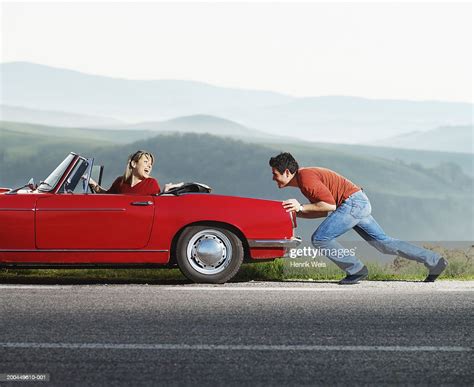 Woman In Red Convertible Car Being Pushed By Man Side View High Res