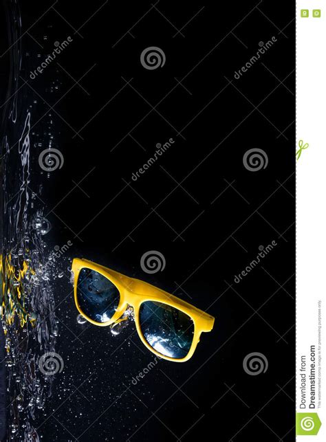 Yellow Sunglasses Splashing Into Water On Black Background Eyewear Falling Into Water Copy