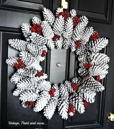 A Wreath Made Out Of Pine Cones Hanging On The Front Door With Red