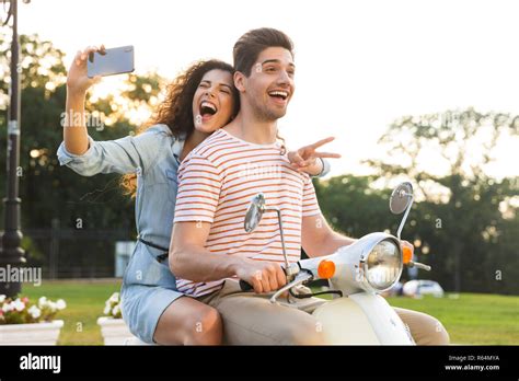 Portrait Of Cheerful Woman Taking Selfie On Smartphone While Riding On