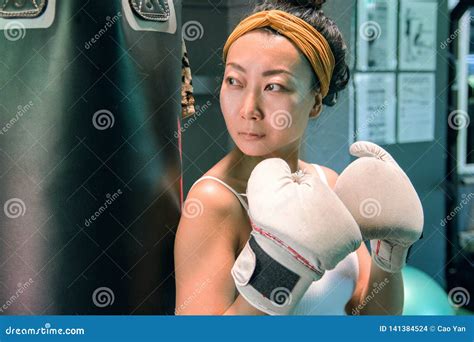 Beautiful Asian Girl With White Boxing Gloves Standing Near A Pear In
