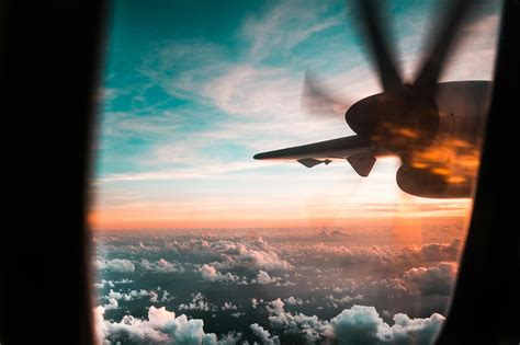 Airplane Flying Over Clouds During Sunset · Free Stock Photo