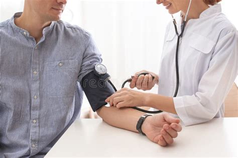 Doctor Checking Patient`s Blood Pressure In Hospital Closeup Stock