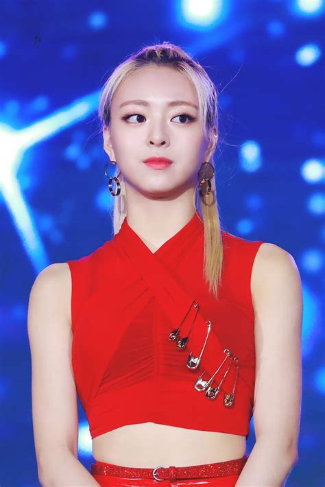 A Woman In A Red Top And Silver Earrings