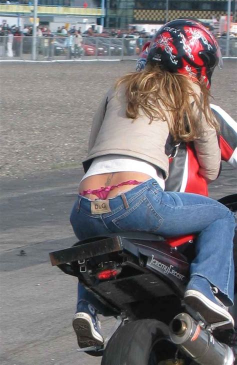 A Woman Riding On The Back Of A Motorcycle