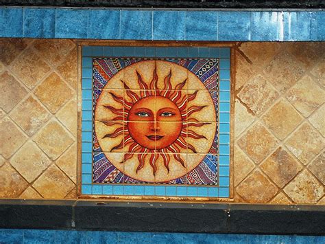 An Artistic Tile Mural On The Side Of A Building With A Sun Painted On It