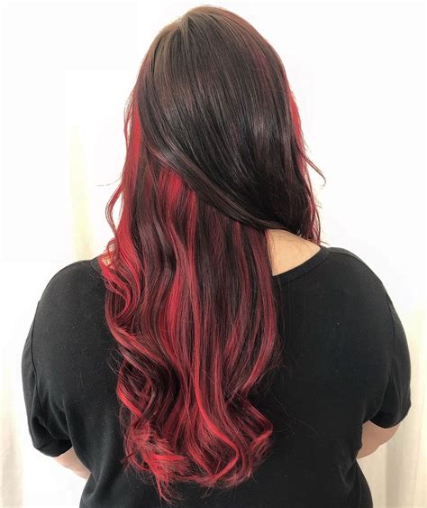 red peek a boo balayage fashion fun color for spring brunette long hair curls bright red hair
