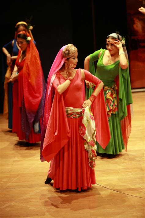 Three Women In Red And Green Dresses On Stage