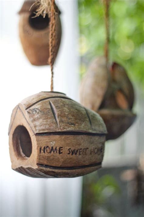 Two Wooden Bird Houses Hanging From Strings With Words On Them That