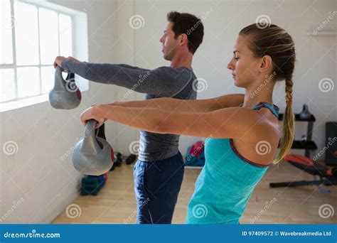 Side View Of Athletes Lifting Kettlebells Stock Photo Image Of Club