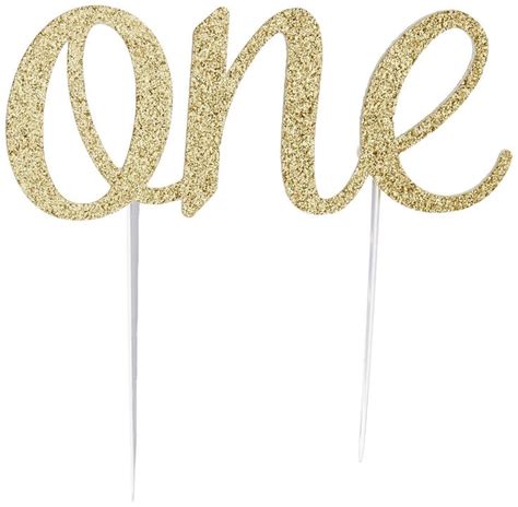 Gold Glitter Cake Topper With The Word One On It And Two Sticks