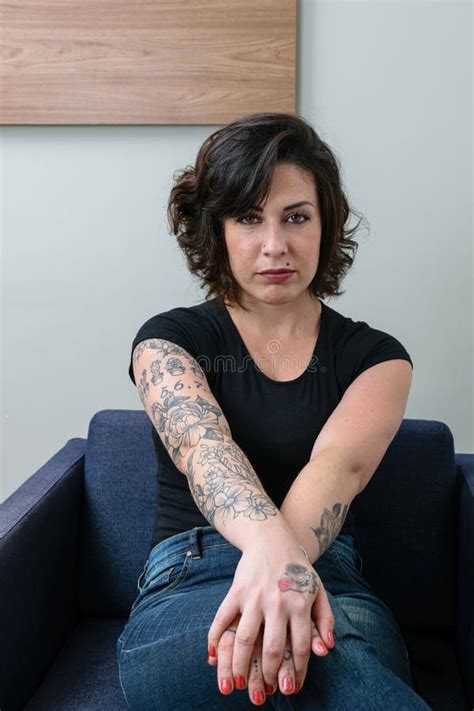 Brazilian Woman Tattooed With Her Hands Crossed And Facing The Camera