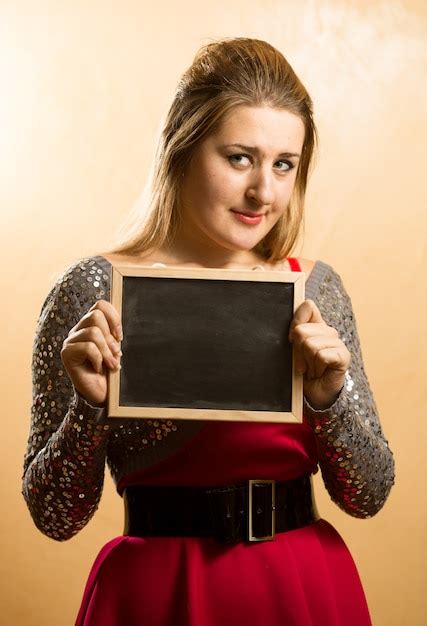 premium photo cute shy woman posing with empty blackboard