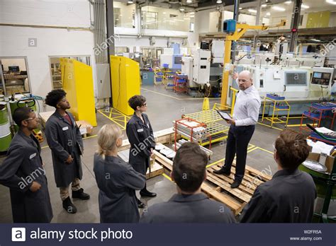 Male Supervisor Talking With Machinists In Factory Stock Photo Alamy