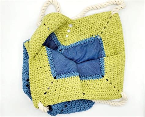 A Crocheted Bag With Blue And Yellow Squares On It Hanging From A Rope